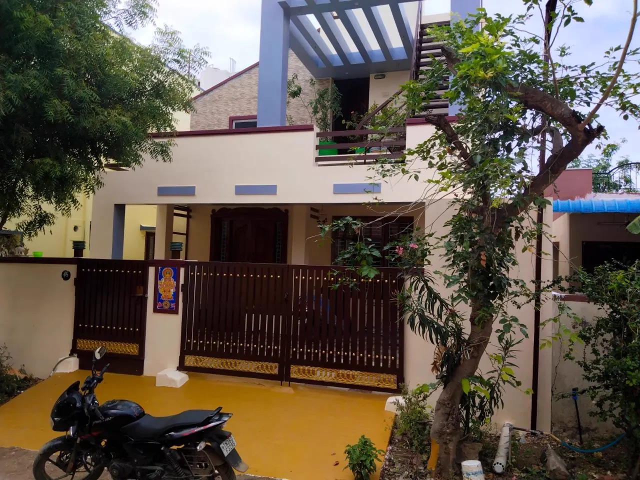 Residence exterior in ivory with maroon trims and yellow coated driveway