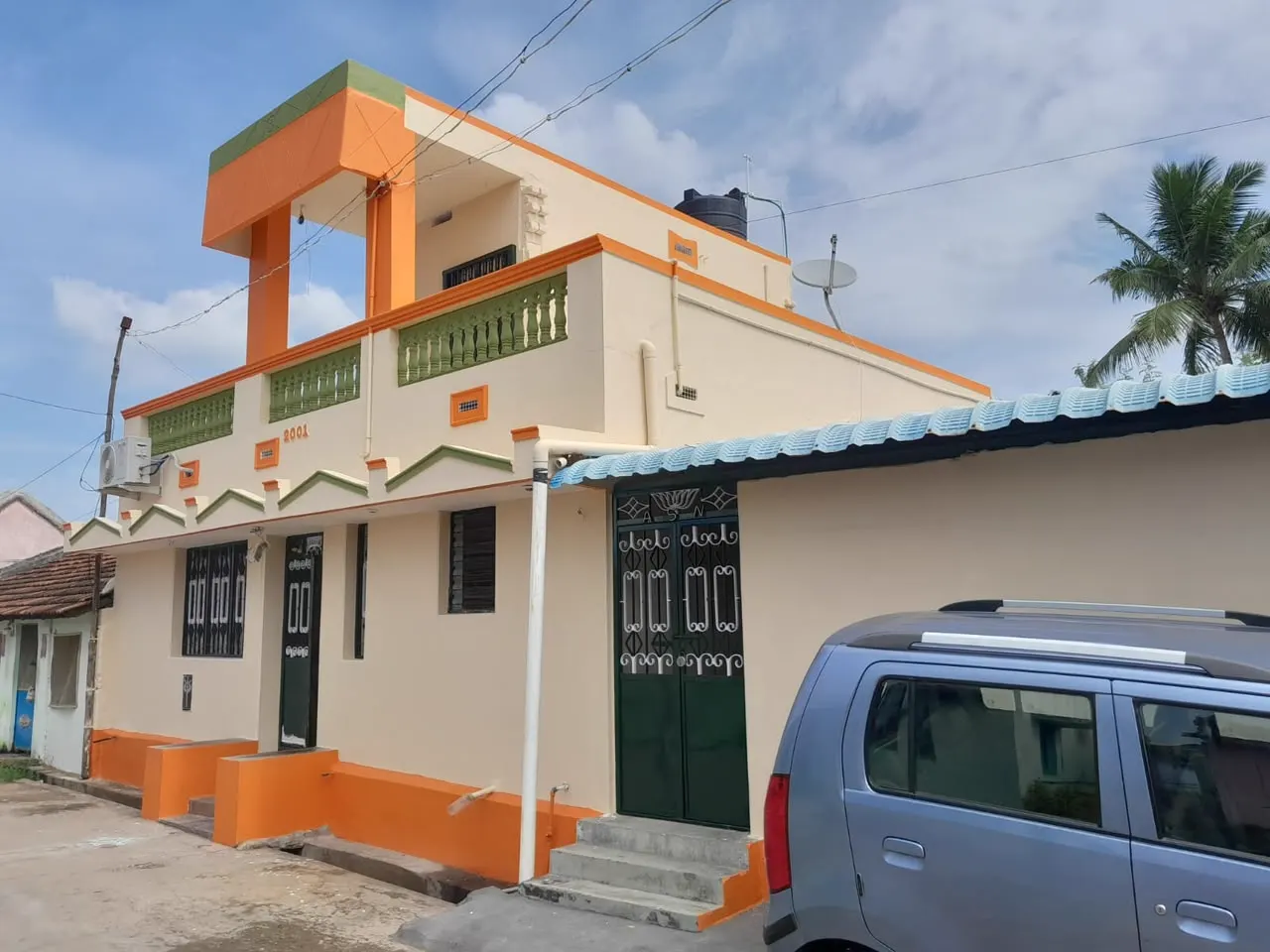 Residence exterior painted cream with orange bands and green balustrades