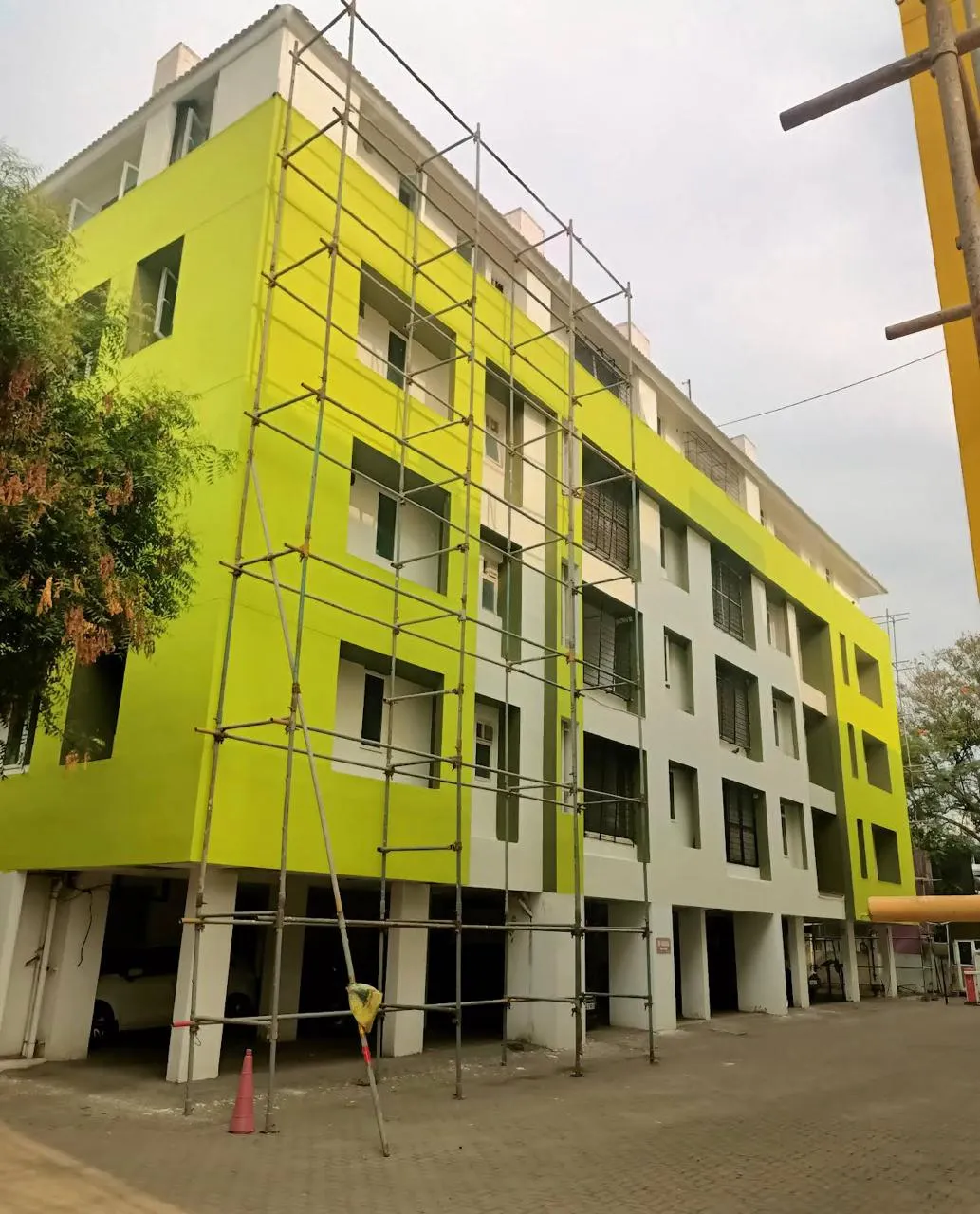 Multi-storey apartment building repainted lime green and white with scaffolding in place