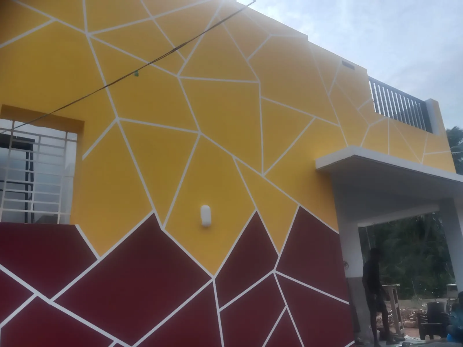 Large geometric wall design in gold and deep maroon panels