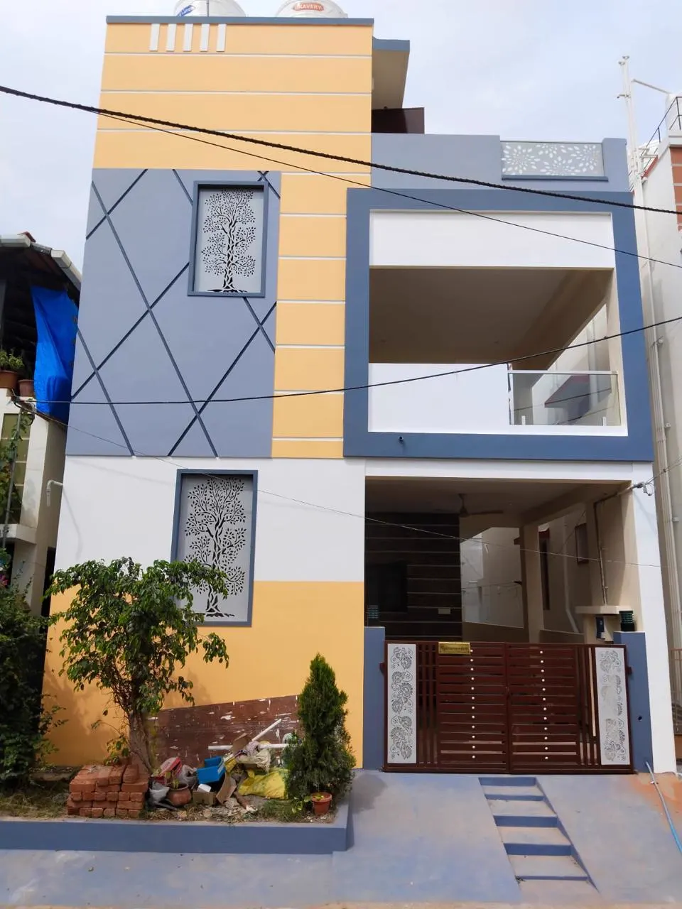 Duplex house exterior painted yellow and grey with diagonal line detailing